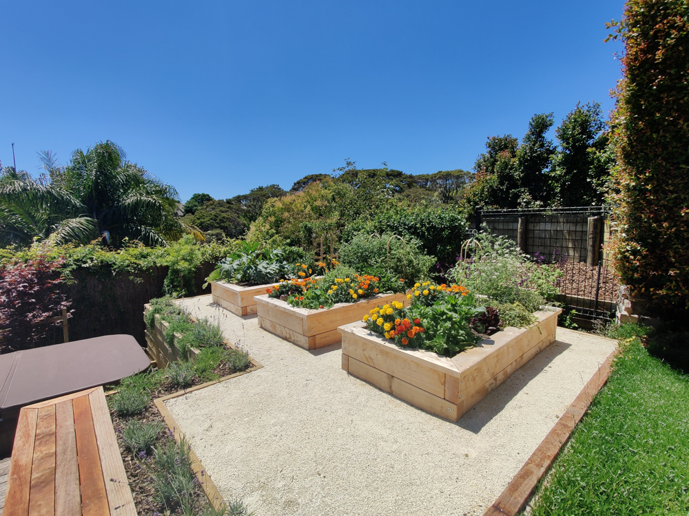 Planter boxes on tiered garden beside deck, lawn, and spa
